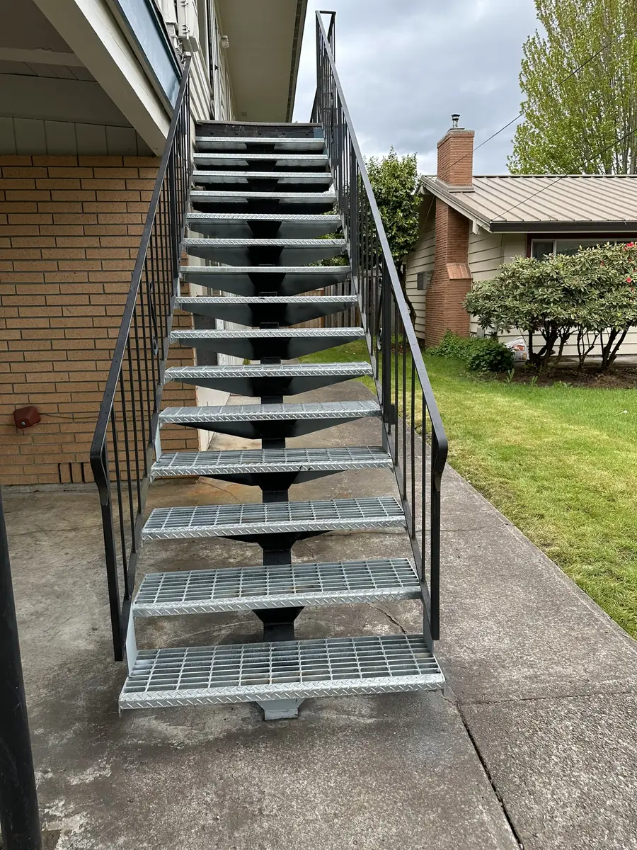 Outdoor steel stairs with grating treads and black railings