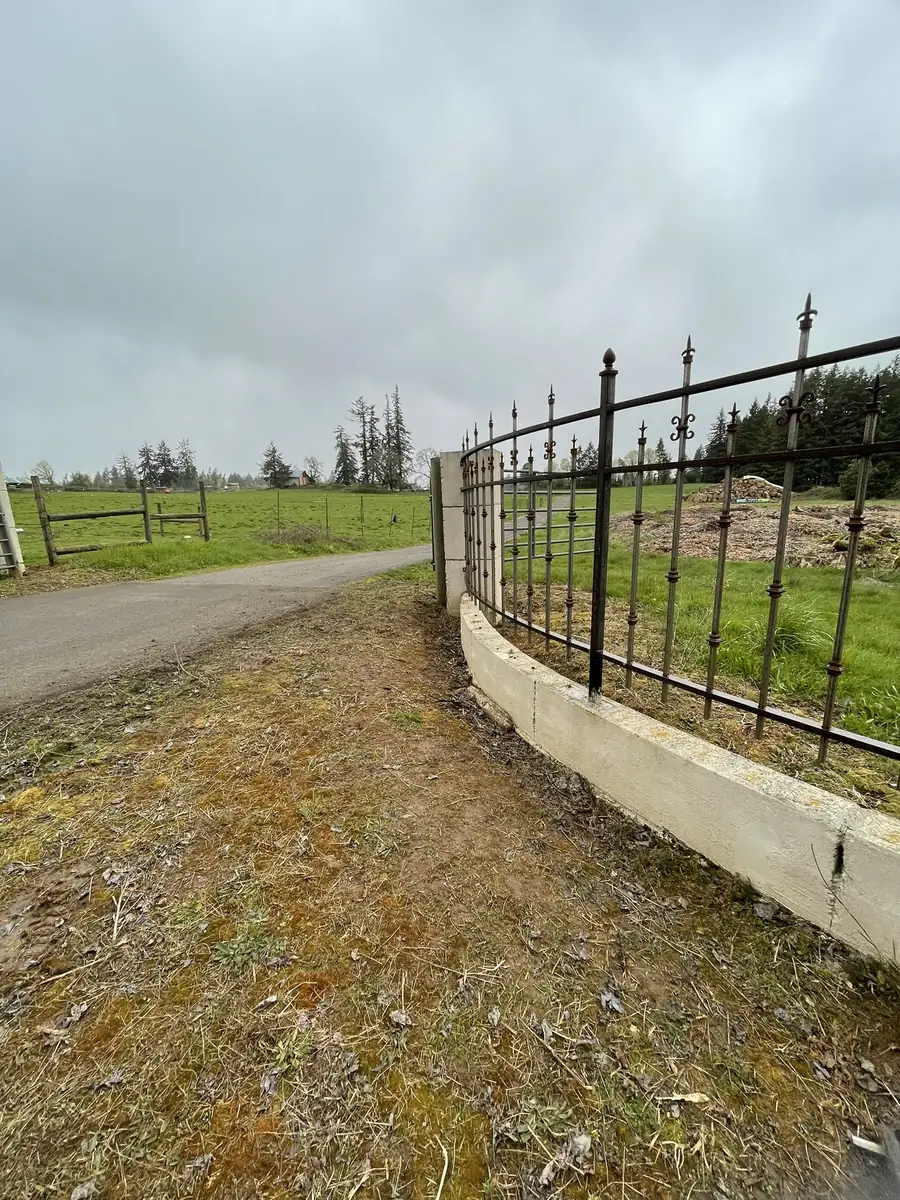 Iron fence with spear tops along a curved concrete wall