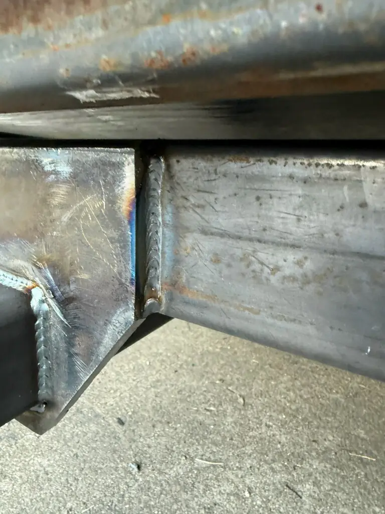 Close-up of the gusset welds where the receiver mount meets the trailer frame