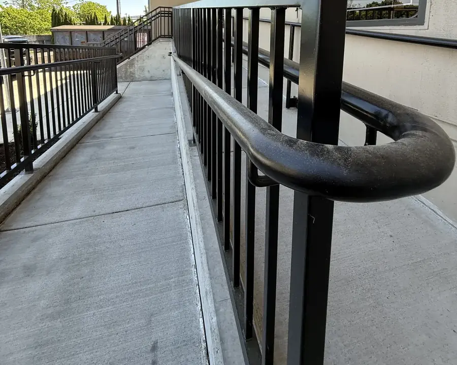 Curved end of a black steel ramp handrail Neal built